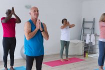 Разнообразная группа пожилых людей, принимающих участие в занятиях фитнесом дома. здоровье фитнес-благополучие в доме престарелых. — стоковое фото