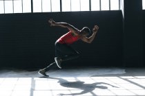 Uomo afroamericano che indossa vestiti sportivi che corrono in un edificio urbano vuoto. fitness urbano stile di vita sano. — Foto stock
