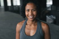 Portrait of african american woman standing in an empty urban building looking at camera. urban fitness healthy lifestyle. — Stock Photo