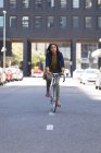 Африканська американка їде на велосипеді на вулиці. Життя під час коронавірусної ковини 19. — стокове фото