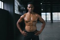 African american man standing and flexing his muscles in empty urban building. urban fitness healthy lifestyle. — Stock Photo
