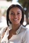 Retrato de una mujer afroamericana sonriendo en la calle. estilo de vida concepto de vida durante el coronavirus covid 19 pandemia. - foto de stock