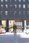 Femme afro-américaine à vélo dans la rue. mode de vie vivant pendant la covie coronavirus 19 pandémie. — Photo de stock