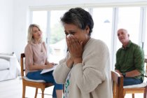 Diverse group of seniors talking during a group therapy session at home. health fitness wellbeing at senior care home. — Stock Photo