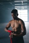 African american boxer taping hands for training  in an empty urban building. urban fitness healthy lifestyle. — Stock Photo