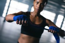 Afroamerikanische Boxerin klebt Hände für das Training in einem leeren städtischen Gebäude ab. urbane Fitness gesunder Lebensstil. — Stockfoto