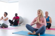 Groupe diversifié d'aînés prenant part à des cours de yoga à la maison. santé fitness bien-être au foyer de soins pour personnes âgées. — Photo de stock