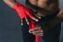 Boxeador afroamericano pegándose las manos para entrenar en un edificio urbano vacío. aptitud urbana estilo de vida saludable. - foto de stock