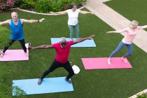 Vielfältige Seniorengruppe beim Fitness-Kurs im Garten. Gesundheit Fitness Wohlbefinden im Altenheim. — Stockfoto