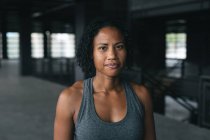 Porträt einer Afroamerikanerin, die in einem leeren städtischen Gebäude steht und in die Kamera blickt. urbane Fitness gesunder Lebensstil. — Stockfoto