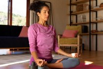 Kaukasische Frau mit geschlossenen Augen meditiert und praktiziert Yoga zu Hause. Zu Hause bleiben in Selbstisolierung während Quarantäne Lockdown. — Stockfoto