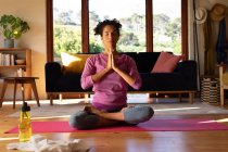 Кавказька жінка з закритими очима медитує, практикуючи йогу вдома. Перебуваючи вдома в ізоляції під час карантину.. — стокове фото