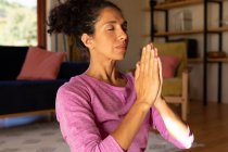 Белая женщина с закрытыми глазами медитирует, практикует йогу дома. Оставаться дома в изоляции во время карантинной изоляции. — стоковое фото