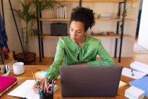 Mujer caucásica usando laptop trabajando desde casa, escribiendo. Permanecer en casa en aislamiento durante el bloqueo de cuarentena. - foto de stock