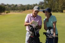 Kaukasische Senioren schreiben Punkte in ein Notizbuch. Golf-Sport-Hobby, gesunder Lebensstil im Ruhestand. — Stockfoto