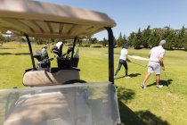 Kaukasische ältere Männer und Frauen gehen weg von Baggie, die Golfschläger halten. Golf Sport Hobby, gesunder Lebensstil im Ruhestand. — Stockfoto