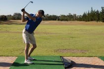 Caucasian senior man holding golf club preparing for shot on the green. golf sports hobby, healthy retirement lifestyle. — Stock Photo