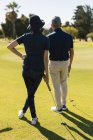 Caucasian senior man and woman preparing to take the shot on the green. golf sports hobby, healthy retirement lifestyle — Stock Photo