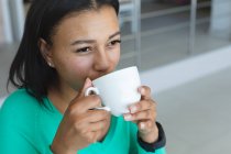 Nahaufnahme einer Afroamerikanerin, die zu Hause Kaffee trinkt. Zu Hause bleiben in Selbstisolierung in Quarantäne — Stockfoto