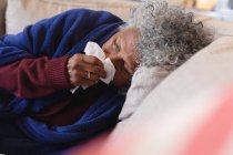 Kranke afrikanisch-amerikanische Seniorin auf der Couch liegend. Zu Hause bleiben in Selbstisolierung in Quarantäne — Stockfoto