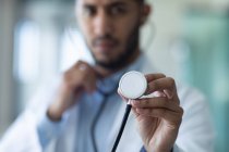 Médico misto de raça masculina usando um estetoscópio. profissional médico trabalhador vestindo estetoscópio e jaleco. — Fotografia de Stock