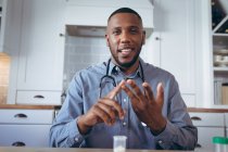 Médico afro-americano a ter uma conversa por vídeo. ficar em casa em auto-isolamento durante o confinamento de quarentena. — Fotografia de Stock