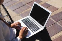 Donna seduta nel parco utilizzando il computer portatile — Foto stock