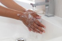 Женщина моет руки в раковине в ванной. оставаться дома в изоляции в карантинной изоляции — стоковое фото