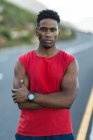 Porträt eines fitten afrikanisch-amerikanischen Mannes, der im Freien auf einer Küstenstraße vor der Kamera trainiert. Fitnesstraining und gesunder Lebensstil im Freien. — Stockfoto