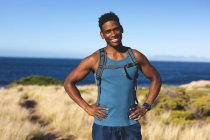 Retrato de ajuste homem americano africano feliz exercitando ao ar livre para câmera. treinamento de fitness e estilo de vida saudável ao ar livre. — Fotografia de Stock