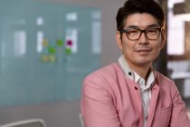 Портрет стильного азіатського бізнесмена, який посміхається до камери. бізнесмен на роботі в сучасному офісі . — стокове фото