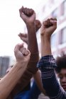 Поднятые кулаки протестующих мужчин и женщин во время марша. Марш за равные права и справедливость. — стоковое фото