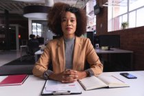 Donna d'affari afroamericana seduta alla scrivania con documenti che fanno videochiamate. attività indipendente di design creativo. — Foto stock