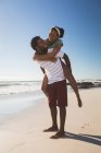 Feliz casal afro-americano na praia a olhar um para o outro. tempo de lazer ao ar livre saudável pelo mar. — Fotografia de Stock