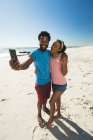 Heureux couple afro-américain sur la plage au bord de la mer prenant selfie. loisirs en plein air sains au bord de la mer. — Photo de stock