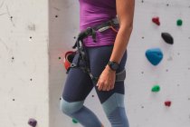 Mittelteil der Frau bereitet sich auf den Aufstieg an der Indoor-Kletterwand vor. Fitness und Freizeit im Fitnessstudio. — Stockfoto