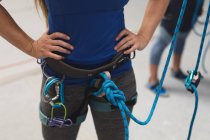 Milieu de la femme se préparant à une montée au mur d'escalade intérieur. fitness et temps libre au gymnase. — Photo de stock