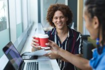 Diverse female business colleagues sitting at window having coffee in meeting. casual meeting in business lounge. — Stock Photo