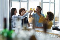 Разнообразная группа коллег-мужчин и женщин, поднимающих бокалы пива в баре. друзья общаются и пьют в баре. — стоковое фото