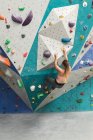 Mujer caucásica trepando por una pared en el gimnasio de escalada interior. fitness y tiempo libre en el gimnasio. - foto de stock