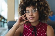 Porträt einer Geschäftsfrau mit gemischter Rasse, die eine Brille auf dem Sofa trägt. Lockeres Treffen in Business-Lounge. — Stockfoto