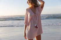Белая женщина, одетая в пляжное прикрытие, развлекается на пляже. здоровый отдых на открытом воздухе у моря. — стоковое фото