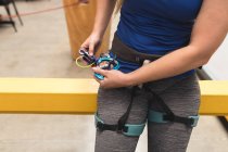 Midsection de mulher se preparando para subir na parede de escalada interior. fitness e tempo de lazer no ginásio. — Fotografia de Stock