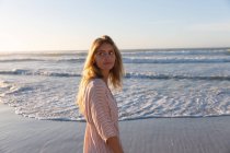Белая женщина, одетая в пляжное прикрытие, развлекается на пляже. здоровый отдых на открытом воздухе у моря. — стоковое фото