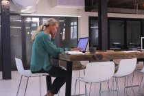 Giovane donna caucasica che utilizza il computer portatile mentre lavora in un ufficio moderno. business, professionalità e concetto di ufficio — Foto stock