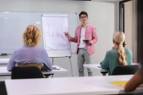 Homem asiático fazendo uma apresentação para seus colegas de escritório na sala de reuniões no escritório. conceito de negócio, profissionalismo, escritório e trabalho em equipe — Fotografia de Stock