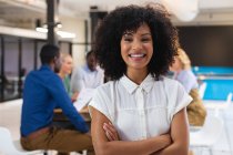 Портрет афро-американської жінки, яка посміхається, стоячи в сучасному офісі. бізнес, професіоналізм і офісна концепція — стокове фото