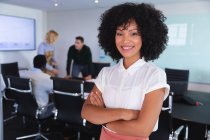 Retrato de mulher afro-americana sorrindo enquanto estava na sala de reuniões do escritório moderno. negócio, profissionalismo e conceito de escritório — Fotografia de Stock