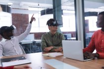 Двое разных коллег по офису носят наушники VR в конференц-зале в офисе. бизнес, профессионализм, концепция офиса и командной работы — стоковое фото