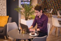 Азиатский бизнесмен, использующий ноутбук в кафе или лобби отеля. деловые поездки, цифровая реклама на ходу и о концепции города. — стоковое фото